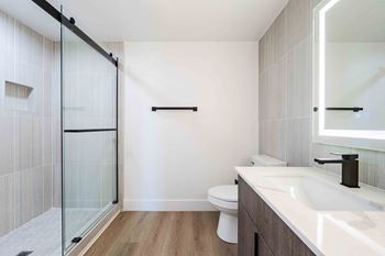 Spacious glass-enclosed showers with rainfall shower head
